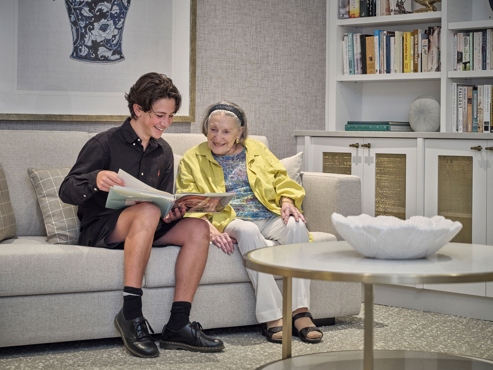 A boy and his grandmother reading in the library