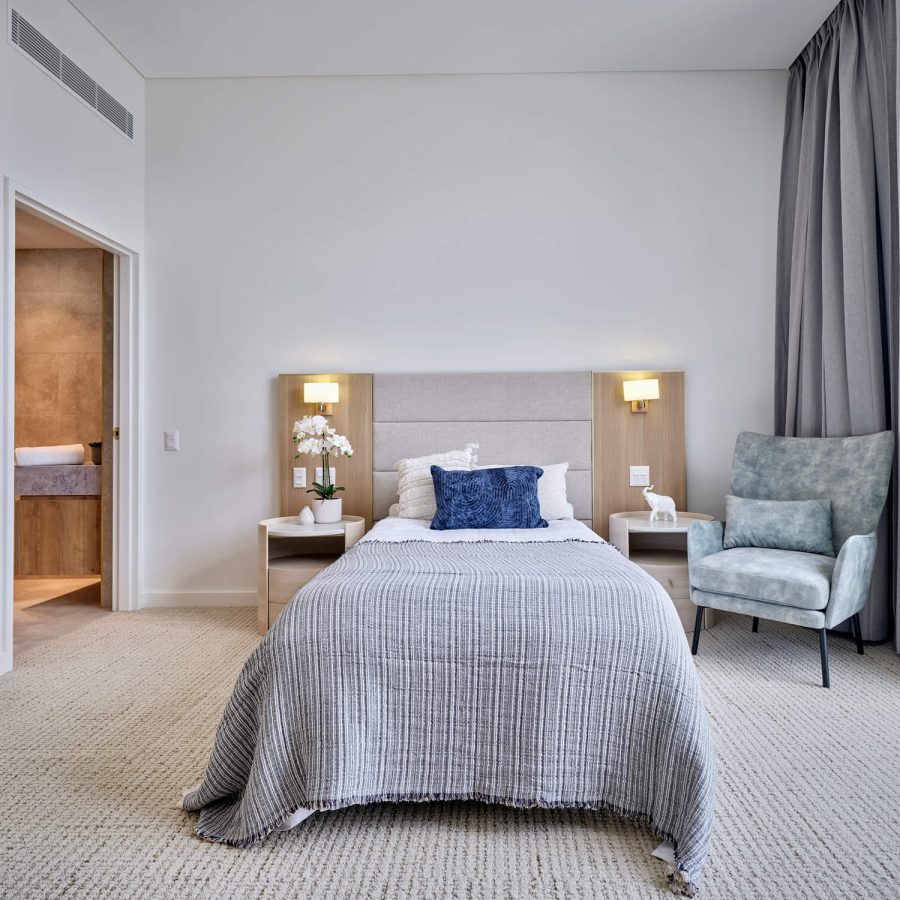 Greenwich Place Superior room bed, high back chair and open bathroom door